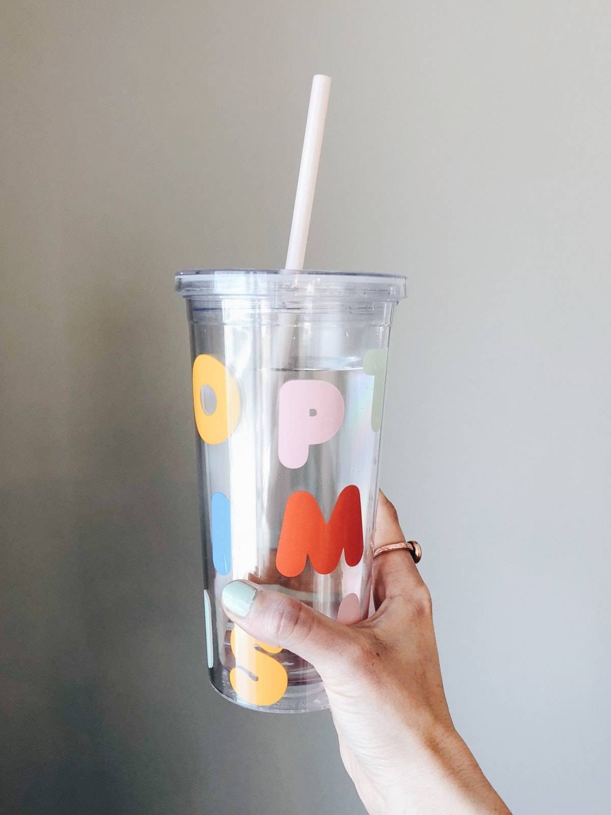 A glass of water with a straw in it.