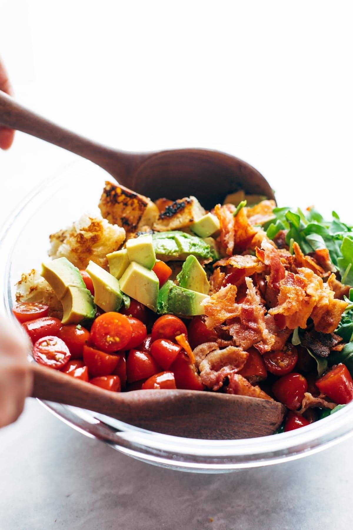 BLT Panzanella ingredients tossed in a bowl.